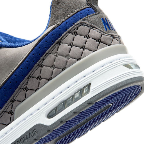 Close-up of a gray and blue sneaker with 'H' logo on a white background